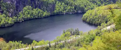 Mountain lake below cliffs and forest in the Adirondacks, New York