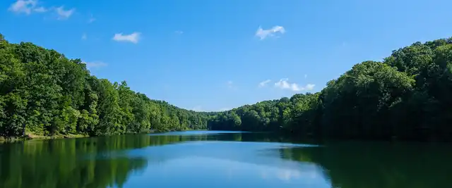 Green forested hills reflected in a lake at Hocking Hills State Park, Ohio