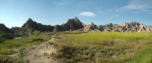 Jagged badland formations above a grassy plain in Badlands National Park, South Dakota